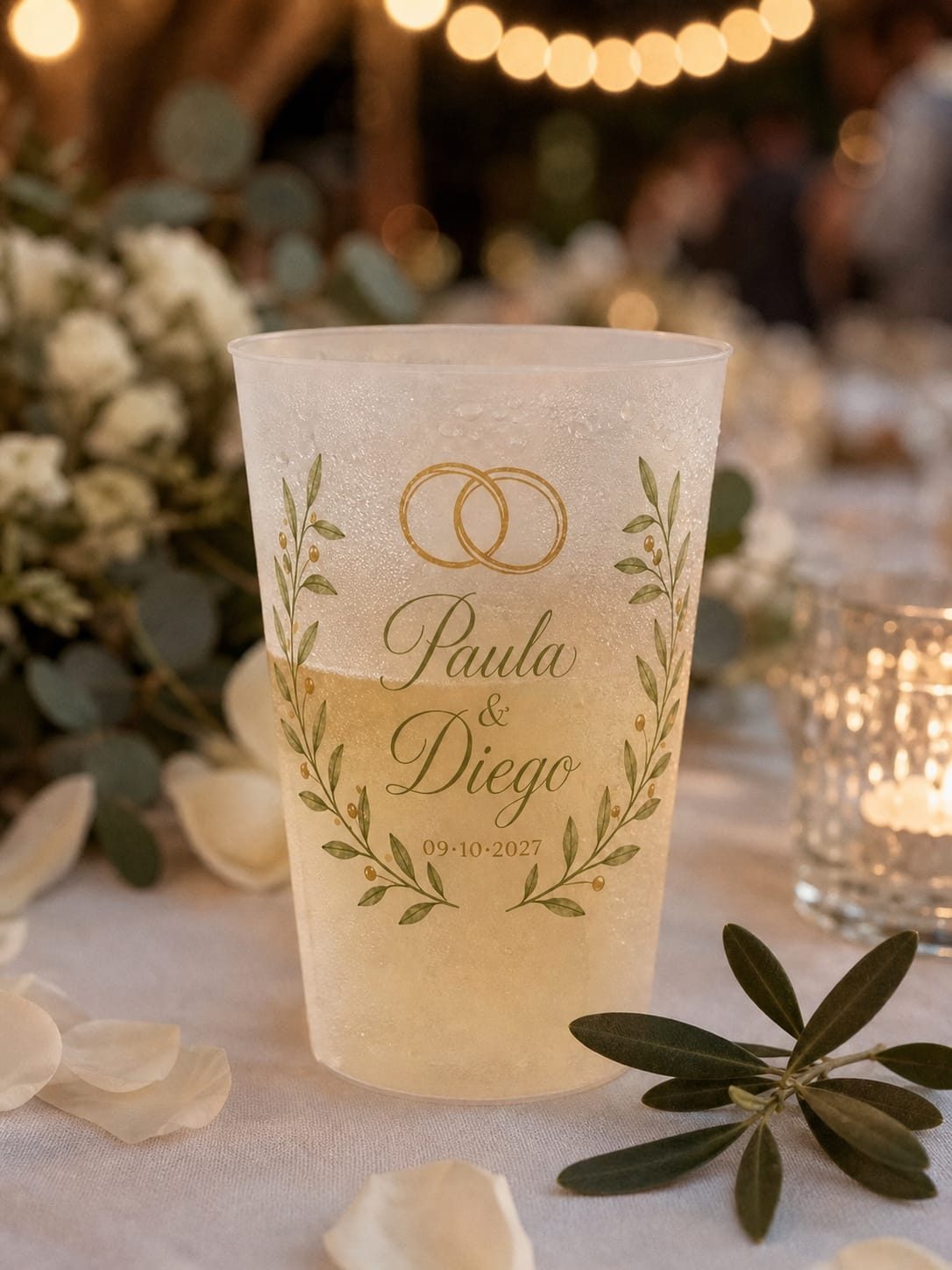 Primer plano de un vaso personalizado con bebida fría, sobre la mesa decorada